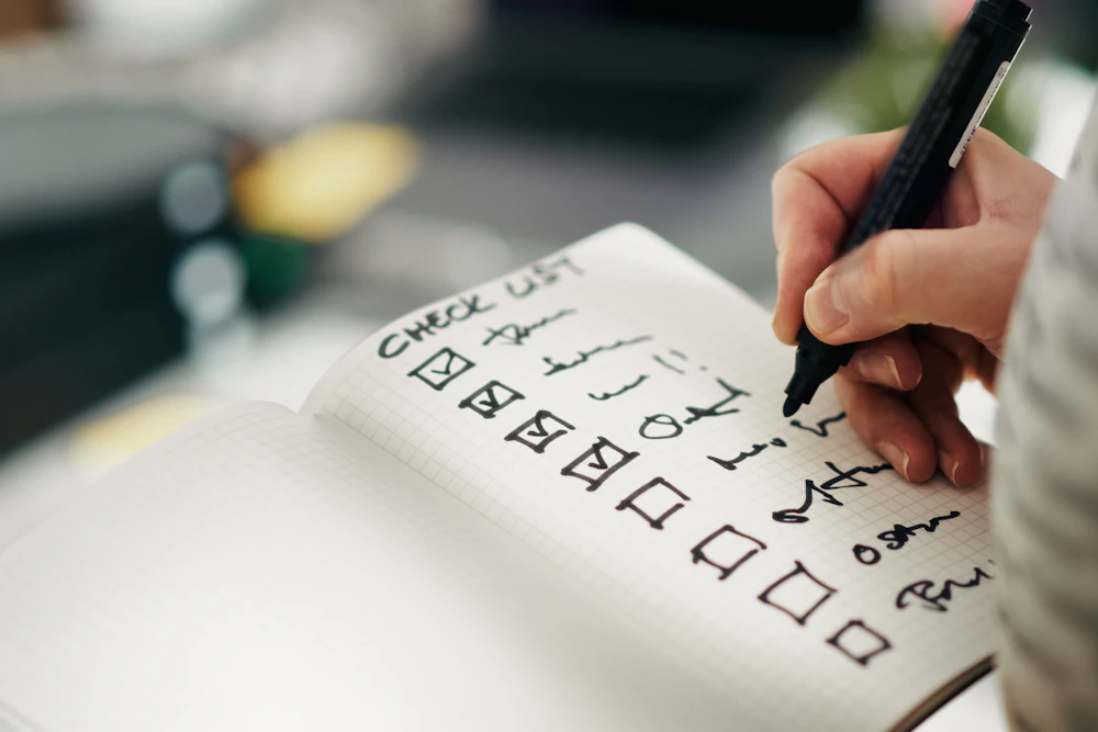 Liste de tâches manuscrite cochée au fil de la journée dans un carnet unique